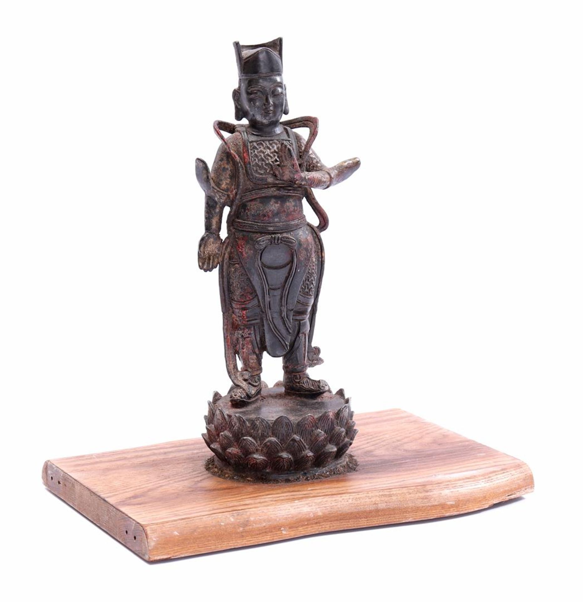 Bronze statue of a Tibetan monk on a wooden plateau