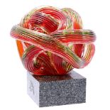 Red glass braided object, on a stone base