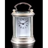 Round travel alarm clock in silver-coloured case