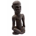 Wooden ceremonial statue of a seated person