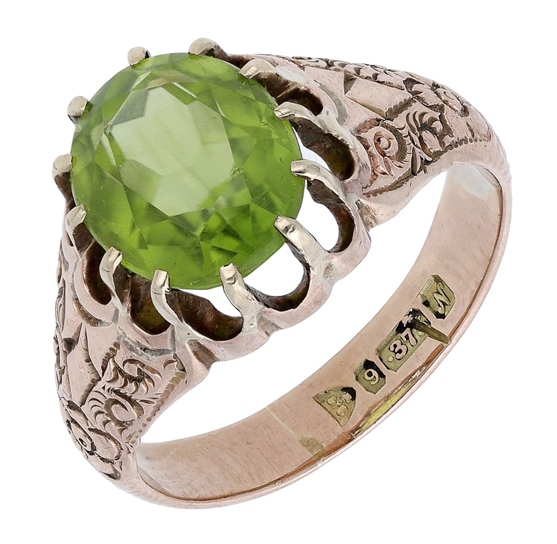 A peridot ring, 1913, the oval-cut peridot within a gold tapering mount engraved with foliate dec...