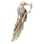 A ruby and diamond bird clip brooch, the bird seated on a branch, its breast inset with a panel o...