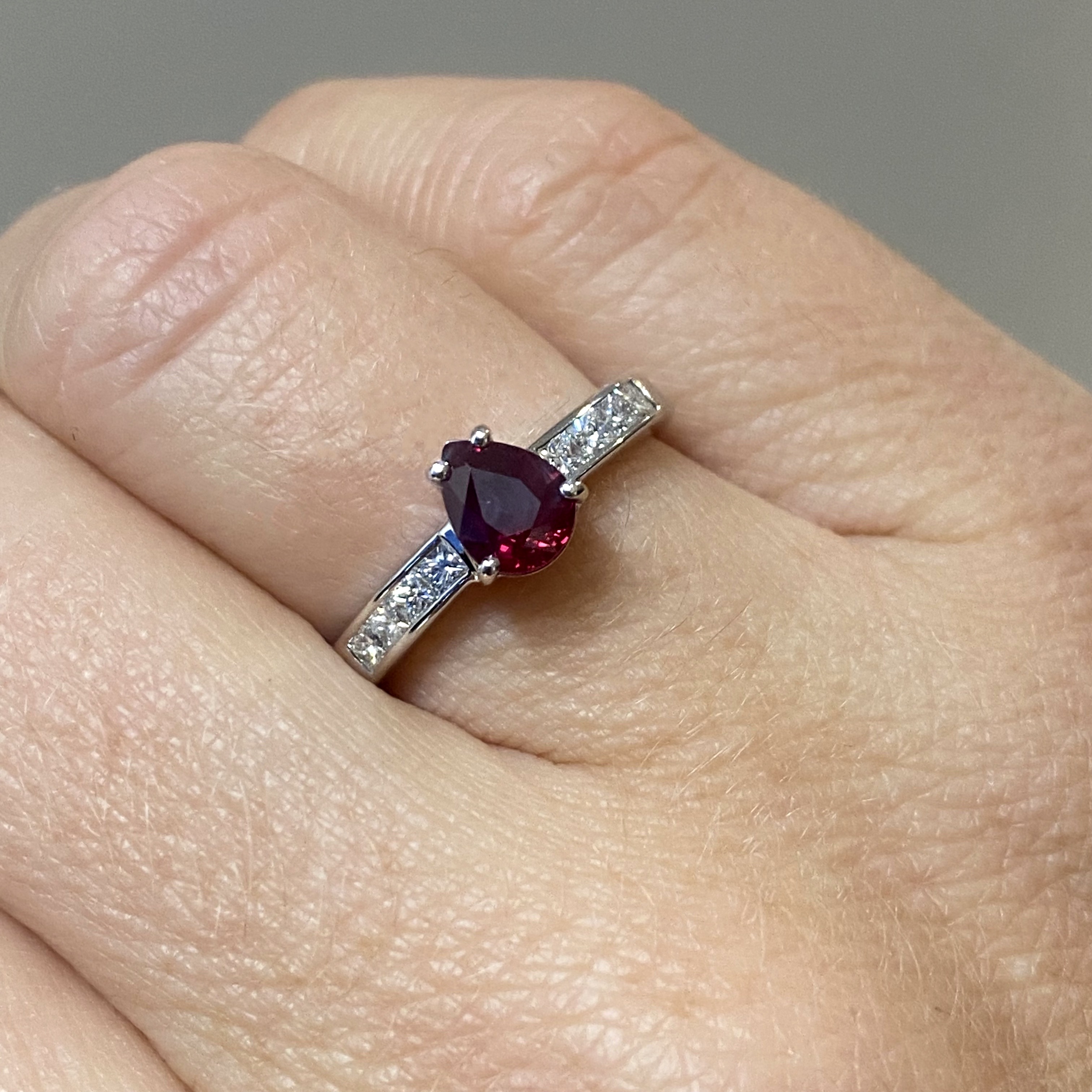 A ruby and diamond ring, the pear-shaped ruby claw-set to princess-cut diamond shoulders, st... - Image 3 of 3