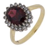 A garnet and diamond cluster ring, the oval-cut garnet claw-set within a surround of single-...