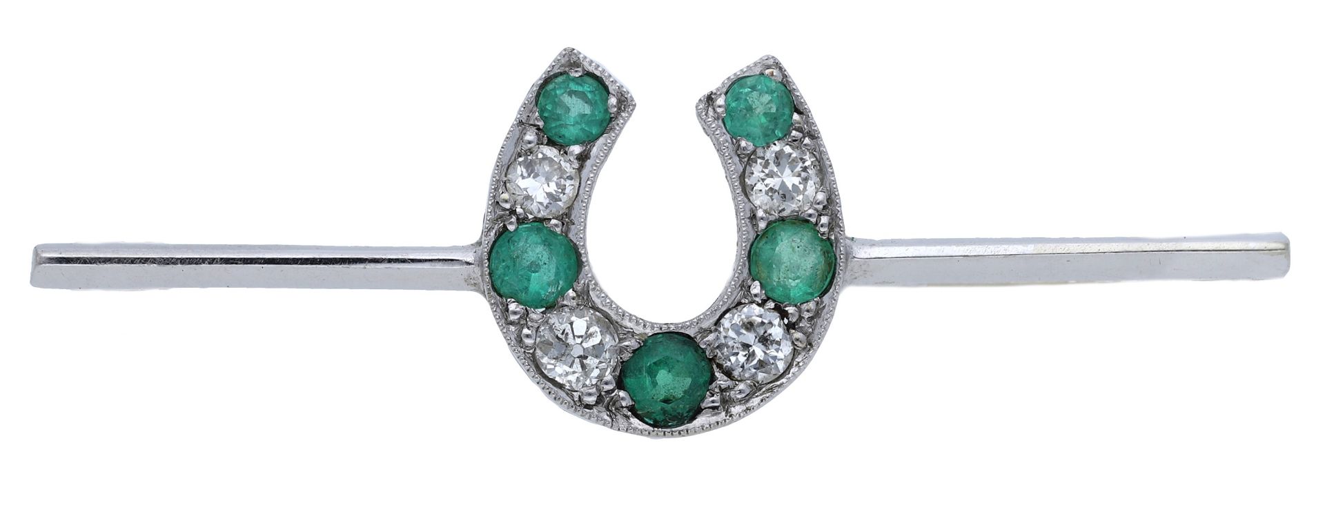 An early 20th century emerald and diamond brooch, designed as a horseshoe set with circular-...