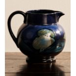 WILLIAM MOORCROFT 'MOONLIT BLUE' JUG CIRCA 1925 the baluster sides painted with trees in a