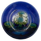 WILLIAM MOORCROFT 'MOONLIT BLUE' DISH CIRCA 1925 painted with trees in a landscape, signed in