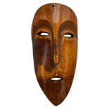 AN AFRICAN IVORY LEGA TRIBAL MASK, FROM ZAIRE, late 19th century, of plain form with ovoid eyes,