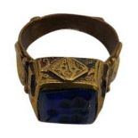 A PERSIAN/BYZANTINE POLISHED BRONZE RING, the raised square top inset with a lapis stone engraved