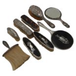 A SILVER HAND MIRROR AND FOUR SILVER BRUSHES, AND A SILVER MOUNTED TORTOISESHELL HAND MIRROR WITH