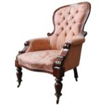 A VICTORIAN MAHOGANY NURSING CHAIR, with scroll carved spoon back, buttoned upholstery supported