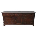 A GEORGE II OAK DRESSER BASE, circa 1760, eight long drawers and a central short drawer, with a