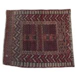 AN INDIAN HAND KNOTTED CARPET, a fawn geometric repeating pattern on a red ground, approximately