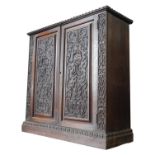 A 19TH CENTURY CARVED OAK TWO DOOR BOOKCASE, the two door panels decorated with foliate carving