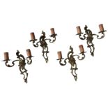 A SET OF FOUR BRASS TWIN BRANCH WALL SCONCE LIGHT FITTINGS, in an ornate scroll foliate style,