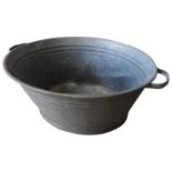 AN OVAL GALVANISED STEEL WASH TUB WITH TWO HANDLES, 30cm high x 80cm wide