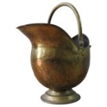 A BRASS HELMET SHAPED COAL SCUTTLE WITH RING HANDLE AND COAL TONGS, 50 cm high