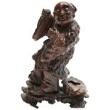 CARVED ROOTWOOD FIGURE OF A BOY QING DYNASTY, 18TH CENTURY modelled standing on a rockwork base