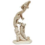 A CHINESE IVORY CARVING OF A SAGE RECLINING UNDER A DRAGON, emanating from a base of stylised