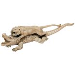 A JAPANESE 19TH CENTURY IVORY OKIMONO OF A LION ATTACKING A CROCODILE, the lioness grasping its