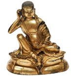 GILT BRONZE FIGURE OF A LAMA 19TH / 20TH CENTURY the figure wearing a long flowing robe open at