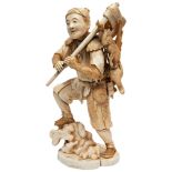A LARGE JAPANESE 19TH CENTURY IVORY SECTIONAL OKIMONO OF A 'WOODSMAN', his foot jauntily upon a rock