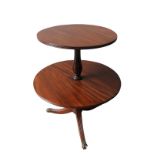 AN EDWARDIAN MAHOGANY REGENCY STYLE DUMB WAITER, two graduated drop-leaf circular table tops