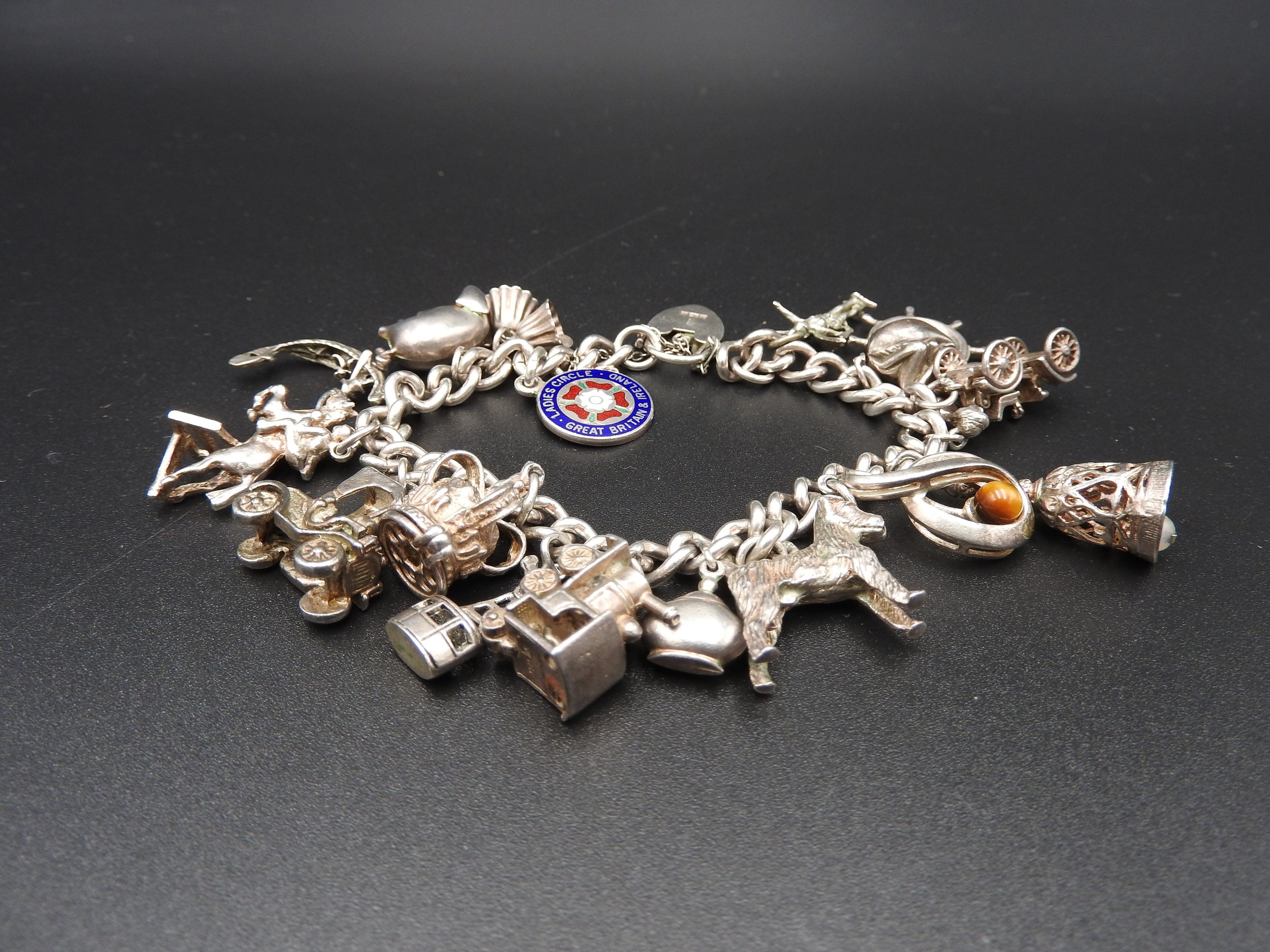 A SILVER CHARM BRACELET, with sixteen assorted charms attached, total weight 72 grams - Image 2 of 2