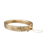 A 9CT GOLD SLAVE BANGLE, partially decorated with foliate pattern, stamped .375, 11.5 grams