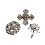THREE FILIGREE DESIGN SILVER BROOCHES One finely worked filigree cross with brooch pin fitting.
