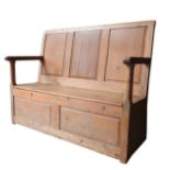 A 19TH CENTURY PINE SETTLE, with three panel back, lift-top seat and open rail arms, 106 x 132 x