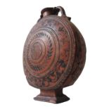 A CONTINENTAL TERRACOTTA MOONFLASK, in the Persian style, hand painted with a central floral