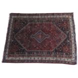 A PERSIAN QASHQAI HAND KNOTTED MEDALLION PATTERN RUG, with a floral border pattern on a deep blue