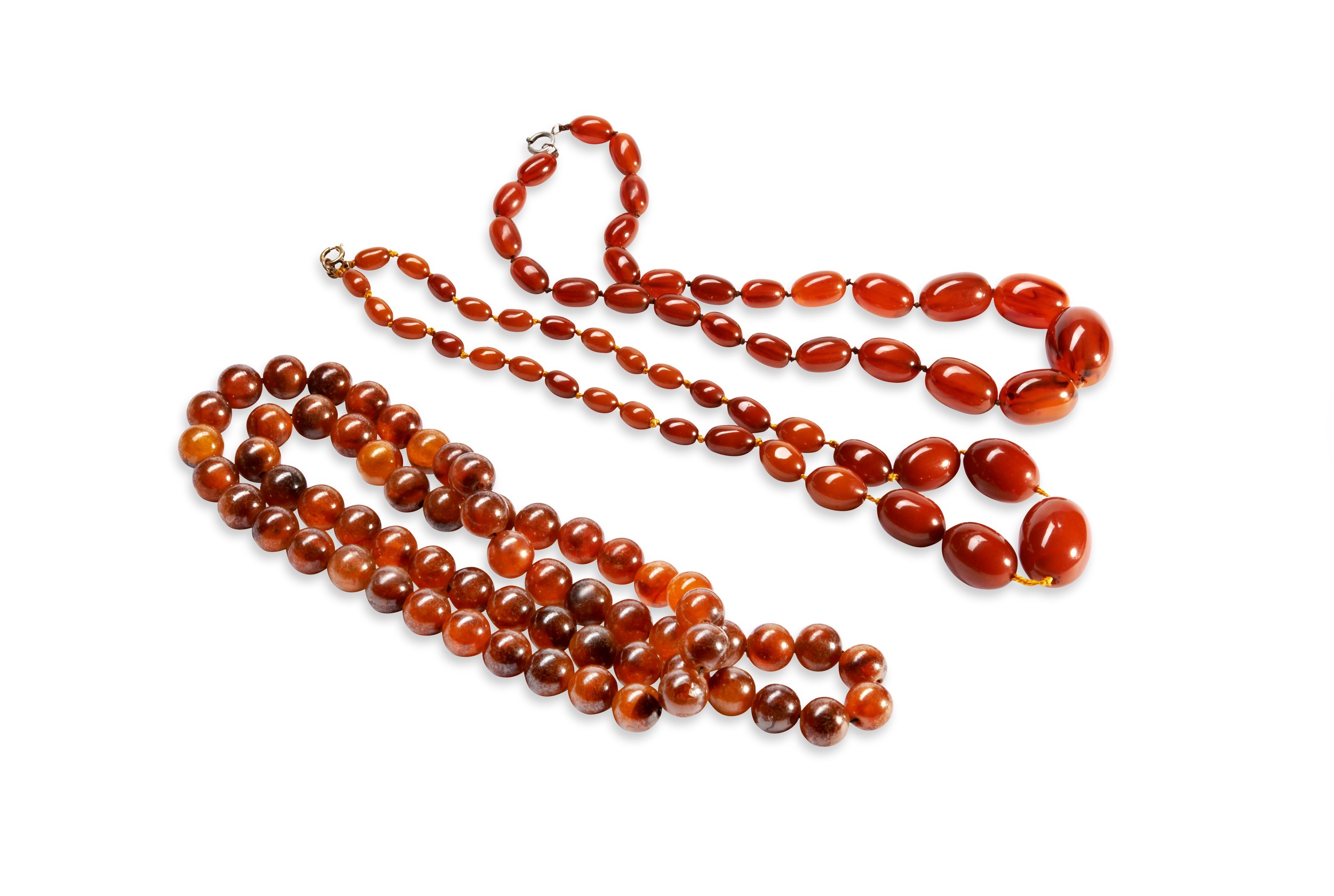 A QUANTITY OF NECKLACES Two dark orange graduating beaded bakelite necklaces. Together with three