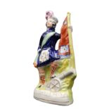 'SCOTLANDS PRIDE' A VICTORIAN STAFFORDSHIRE FIGURE DEPICTING A SCOTTISH SOLDIER WITH CANNON AND