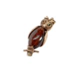 A 9CT GOLD AND GLASS OWL PENDANT Set with a central amber coloured glass bead. Weight 8.9 grams.