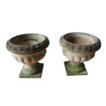 A PAIR OF WEATHERED 'SANDFORD STONE' RECONSTITUTED PLANTERS ON PEDESTALS, with a fluted pattern,