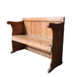 A 19TH CENTURY PINE PEW, with swept scroll arms 85 x 124 x 43 cm