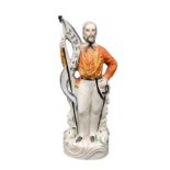 A VICTORIAN STAFFORDSHIRE FIGURE OF GARIBALDI HOLDING A 'LIBERTE' FLAG. 26 cms high