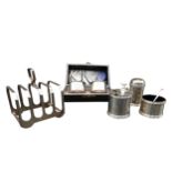 A SILVER CRUET SET, SILVER TOAST RACK AND A PAIR OF SILVER NAPKIN RINGS, circa 1920 and 1940, the