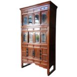 A JAPANESE TWO SECTION TANSU CABINET, both sections containing four glazed sliding doors, the top