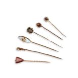 A COLLECTION OF ANTIQUE STICK PINS Six in total, including a yellow metal mourning pin in the form