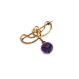 AN ART NOUVEAU AMETHYST AND GOLD BROOCH, CIRCA 1890, the faceted amethyst bead suspended from an