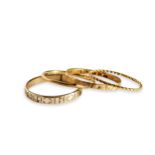 FOUR SMALL GOLD BANDS. Two with chased patterns, one hallmarked 9ct, Birmingham, 1936, size M 1/2,