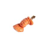 A CORAL PENDANT, CIRCA 1890 carved as a Buddha, on a simple hinged gold bale Total weight 9.6gms 4.