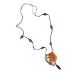 AN ART NOUVEAU CARVED HORN NECKLACE BY E.BONTI In the form of a stylised nasturtium flower carved