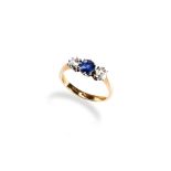 A DIAMOND AND SAPPHIRE THREE STONE RING set with two cushion cut, claw set diamonds, and one central