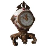 A CERAMIC THISTLE PAINTED DESK CLOCK, of globular form with rococo style gilt metal mounts and base,