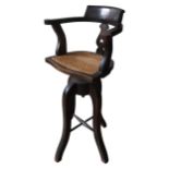 A VINTAGE OAK BOW BACK ADJUSTABLE REVOLVING STOOL, with pierced splat, cane seat and four shaped