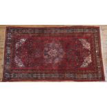A PERSIAN HAND KNOTTED HAMADAN RUG, deep border pattern with floral motifs on a red ground, 270 x
